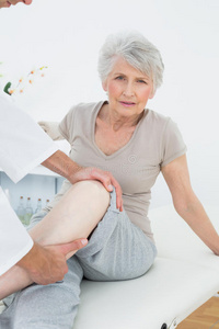 一位老年妇女接受腿部检查的画像