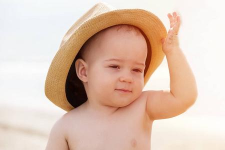 微笑的小男孩在海滩上玩头发的肖像
