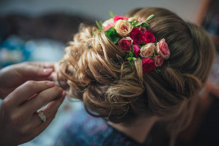 时尚的婚礼发型与新鲜的玫瑰。漂亮的造型, 后景色。新娘站在他的背上的相机
