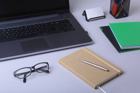 用笔记本电脑笔记本眼镜钢笔和其他设备在办公地点的舒适工作场所特写与复印空间