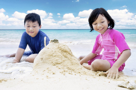 小女孩和她的哥哥玩沙子
