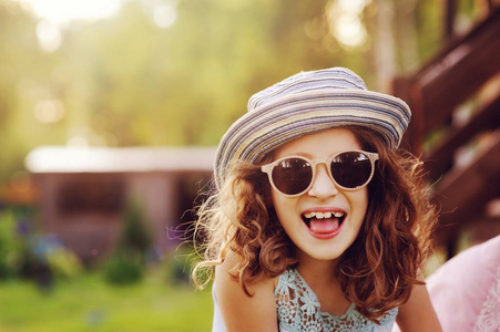 夏天的肖像快乐的孩子女孩度假时戴着太阳镜和帽子，笑着露出舌头。