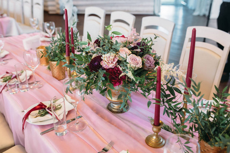 带花蜡烛金花瓶和桉树装饰的浅色椅子的客人餐桌