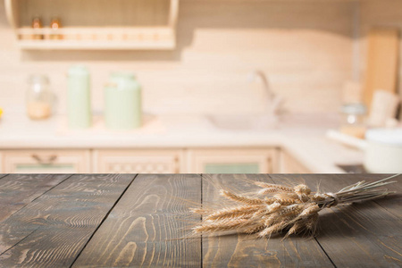 模糊和抽象的厨房背景。木制桌面与小麦和弥散现代厨房展示您的产品
