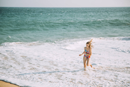 美丽的年轻女子穿着泳衣在沙滩上放松
