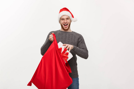 圣诞概念年轻的快乐胡子男子兴奋与大礼物在圣诞老人袋