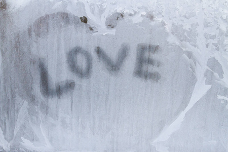 在冬天的花纹在冰冻的窗户上写上爱的铭文