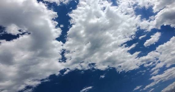 深蓝色阳光明媚的天空, 白云。蓝色的天空与云特写。蓝天上的白色蓬松的云