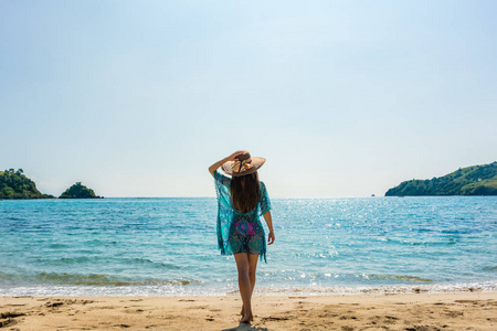 年轻适合的妇女站在热带海滩上的暑假