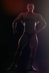 肌肉男健美训练在健身房和摆姿势肌肉