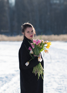 冬天街上一个年轻漂亮女孩和郁金香的肖像