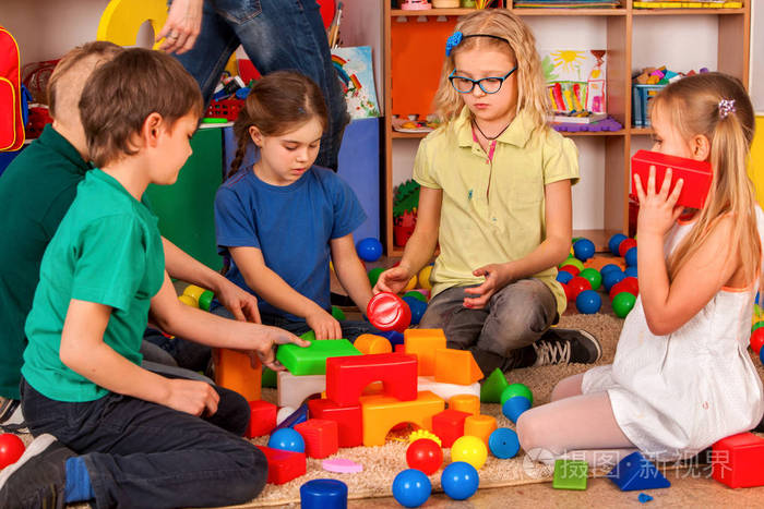 儿童幼儿园中的构建基块.组孩子玩玩具地板