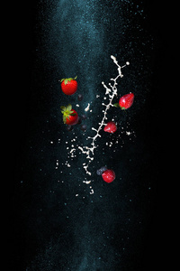 草莓和牛奶的黑色背景。在零重力下停止瞬间