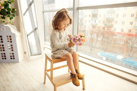 s day sits at the window and laughs at her mother, gives a bouqu