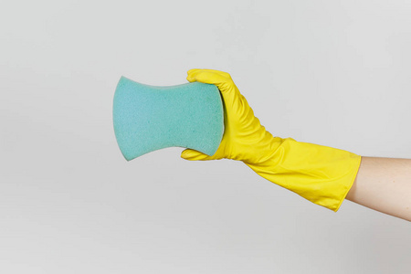 女性手的特写在黄色手套水平举行蓝色大海绵为清洗和洗涤盘子被隔绝在白色背景。清洁用品的概念。复制广告空间