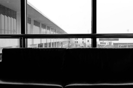 在机场候机室的窗户附近的沙发剪影