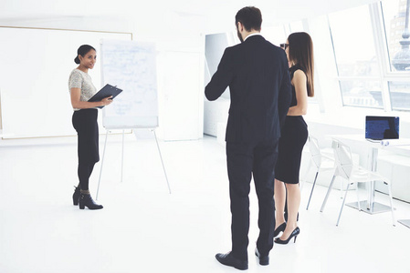 你这位美国女经理用挂图为同事发表创意演讲。在会议期间与合作伙伴沟通创业的职业女性