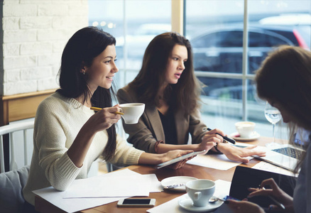 一群同事一起制定商业计划，享受与咖啡的富有成效的合作，女伙伴在非正式会议上谈论创业咨询的想法