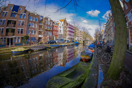 阿姆斯特丹运河上的房屋和船与冻结的河流美丽的户外景观, 荷兰风格的彩色房屋的早晨照片与在水中的倒影