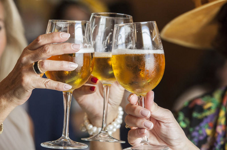 三名成熟女性喝杯啤酒干杯在阳光明媚的夏日,一群朋友在游泳池边嬉戏