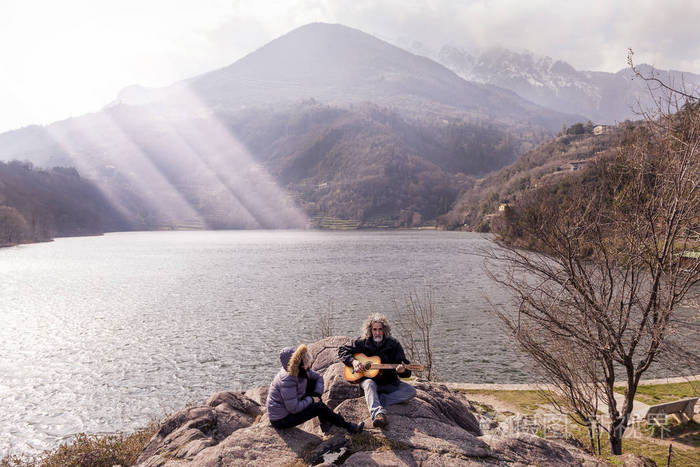 美丽的成熟夫妇玩吉他坐在湖边照片-正版商用图片11qnkq-摄图新视界