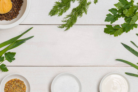 白色木制厨房餐桌的背景与健康的烹饪成分和复制空间。沙拉用的蔬菜和草药。纯素食有机食谱膳食框架