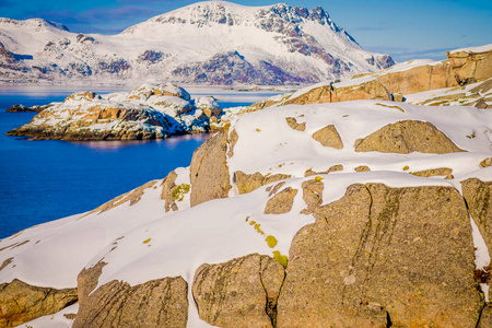 北极冰雪覆盖的冬季露天大岩石上的积雪融化
