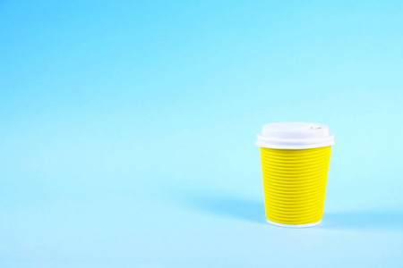 色彩简单化的最小成分与耐热纸咖啡杯。拿出带塑料瓶盖的茶杯。咖啡店理念