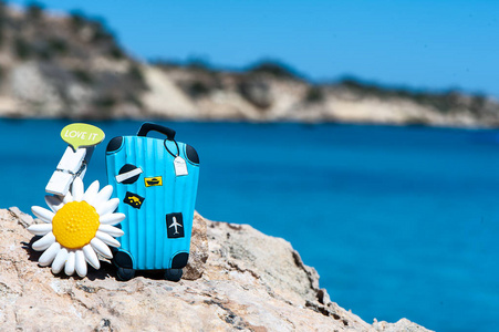 概念旅行到海。时髦的手提箱对蓝色海