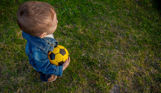 两岁男孩在公园里保持足球, 顶部视图
