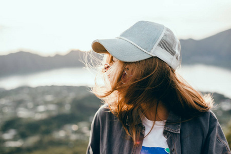 女旅行者看着林贾尼火山岛伦博克。 年轻的背包客沿着山区旅行快乐的女性散步发现世界暑假概念手中的赢家巴厘岛