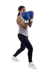黑人女性被隔离在白色背景上，戴着拳击手套，配合拳击有氧运动。 她摆出拳头，描绘健身或自卫和武术。