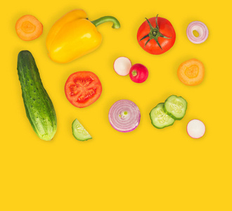 蔬菜混合在黄色孤立的背景上。 新鲜黄椒切番茄洋葱圆黄瓜片胡萝卜萝卜。 健康生活方式的概念。 素食。
