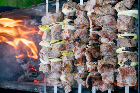 羊肉串烤肉串在烤架上烤。烧烤派对特写