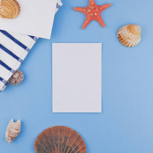 创意广场平面布局概念暑期旅游度假。 海滩毛巾贝壳和海星的顶部视图，在彩色蓝色背景上，复制空间以最小的样式模板为文本。