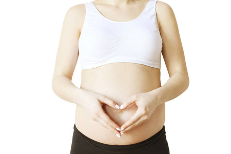  black yoga pants, arms on her belly. Female hands forming heart