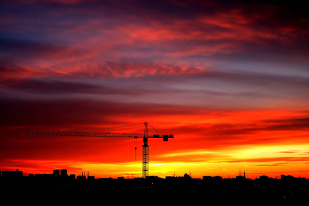 工业建筑起重机和建筑轮廓在日落。