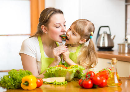 妈妈和孩子在厨房里吃蔬菜