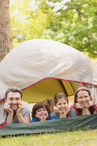 带着孩子的夫妇躺在公园的帐篷里