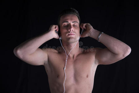 穿运动衫的男子用耳机听音乐图片