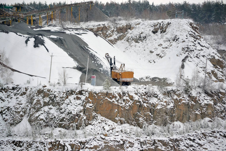 大型大型黄色挖掘机在花岗岩采石场冬季
