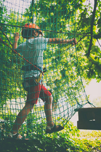 男孩爬上一个吊坠公园