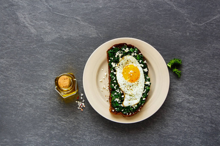 美味的早餐黑麦面包三明治在盘子里，甘蓝煎蛋和FETA奶酪在混凝土背景视图。 健康饮食减肥饮食生活方式的概念。 平躺式。