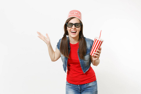 年轻的笑女，戴着3D眼镜，头上戴着爆米花桶，看电影，手里拿着一杯苏打水或可乐，把手放在白色背景上的科普空间上。 电影中的情绪