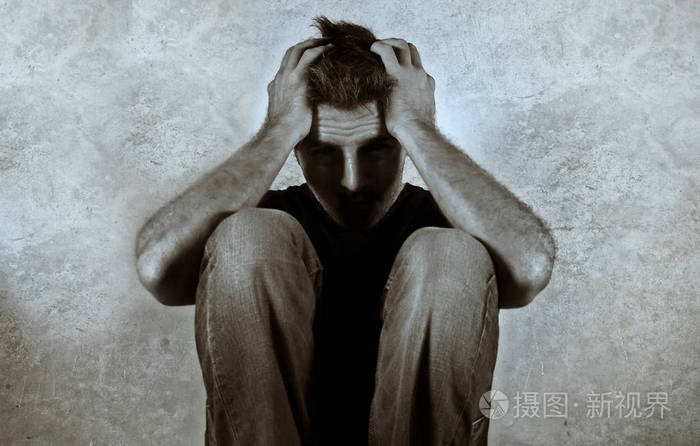 可怕的黑白肖像绝望的男人哭泣悲伤坐在家中的地板上