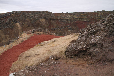 克里德火山口及其蓝色池塘黄金圈冰岛。 冰岛西部美丽的克里奥或克里德火山口的冬季颜色。 红色的火山岩，绿色的苔藓斜坡，在一个绿松石