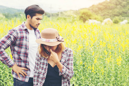 年轻的时髦夫妇夏天在黄花地放松。 享受大自然。