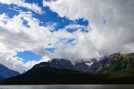 加拿大风景，有蓝白天空的山脉，森林，湖泊，河流和开阔的田野。
