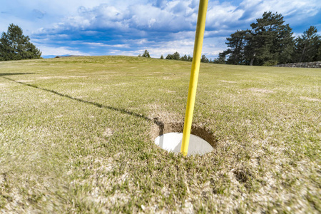 高尔夫球场上放绿色的旗杆和洞