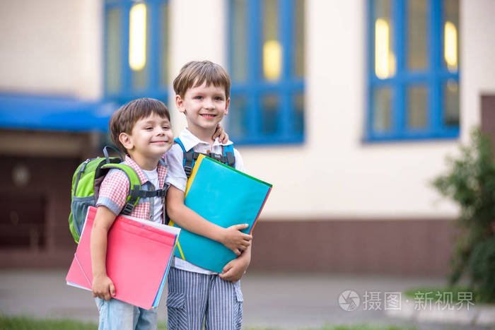 可爱的小学生在校园里轻快地交谈 孩子们心情很好 温暖的春天早晨.